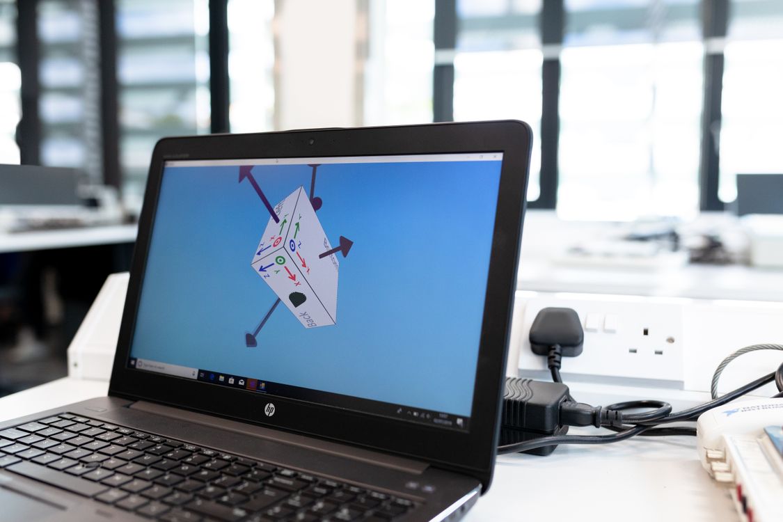 Laptop in a bright office displaying a three-dimensional design inside modelling software.